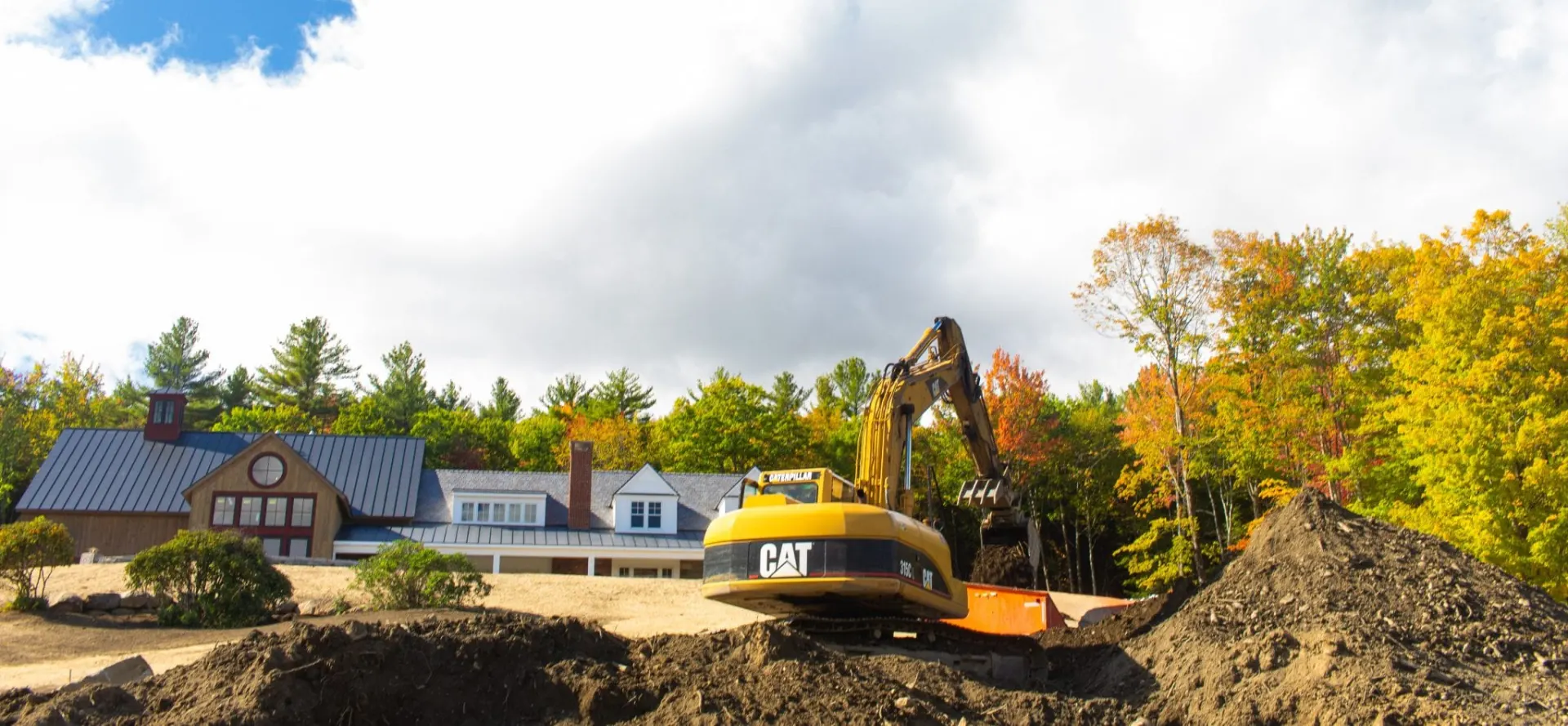 Excavator clearing a Vermont home site for construction
